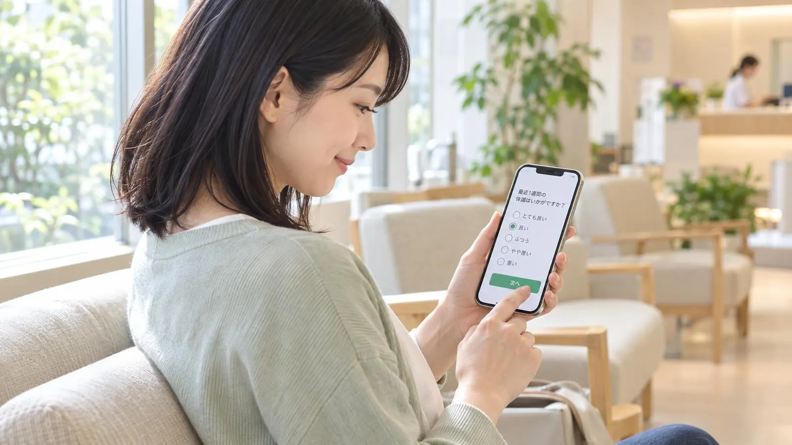 待合室で、スマートフォンからアンケートに答える患者さん